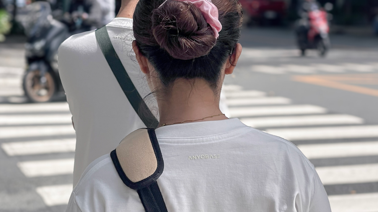 Person wearing the ANYOBASE Core Tee in Off-White featuring a tonal back-neck logo.